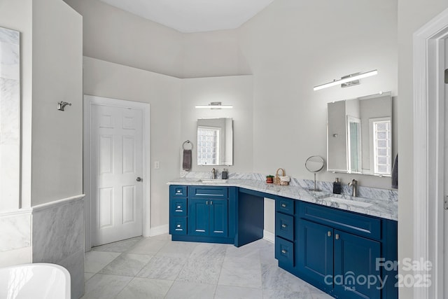 full bath featuring a sink, a freestanding tub, and double vanity