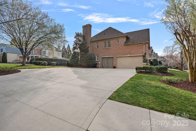 view of side of property with a yard, concrete driveway, a garage, brick siding, and a chimney