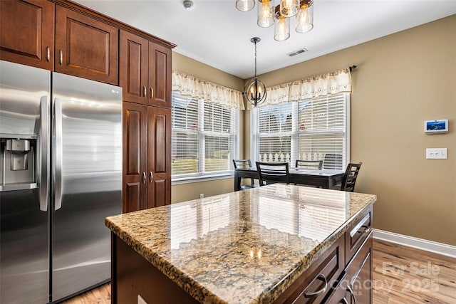 kitchen featuring visible vents, a notable chandelier, stainless steel fridge with ice dispenser, and light wood finished floors