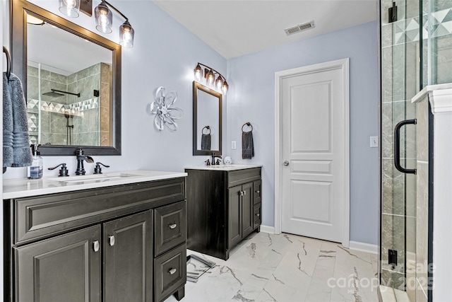 bathroom with visible vents, two vanities, a stall shower, marble finish floor, and a sink