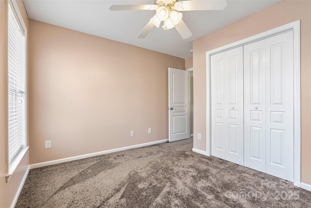 unfurnished bedroom featuring a closet, carpet flooring, multiple windows, and baseboards