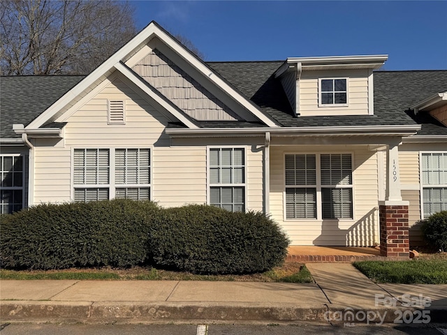 view of front of home with a shingled roof and a porch