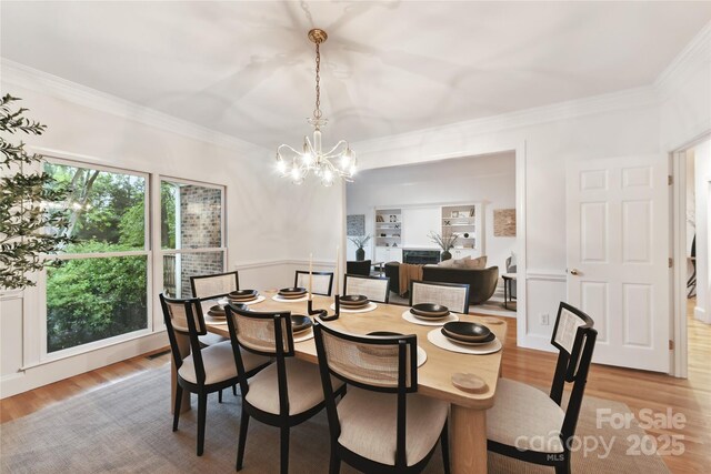 2411 Calais Pl, Charlotte, NC 28211 - dining room with a chandelier, light wood-style floors, and ornamental molding