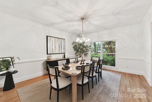 2411 Calais Pl, Charlotte, NC 28211 - dining room featuring a chandelier, wood finished floors, and ornamental molding