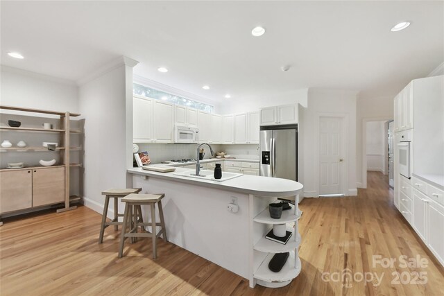 2411 Calais Pl, Charlotte, NC 28211 - kitchen with white appliances, open shelves, a peninsula, white cabinetry, and light wood-style floors