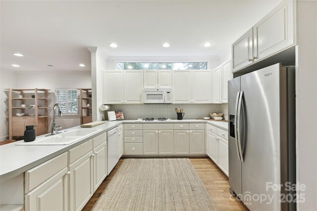 2411 Calais Pl, Charlotte, NC 28211 - kitchen featuring white appliances, a sink, light wood-style flooring, tasteful backsplash, and light countertops