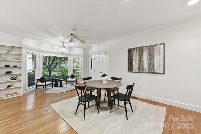 2411 Calais Pl, Charlotte, NC 28211 - dining space with ceiling fan, ornamental molding, baseboards, light wood-type flooring, and a chandelier