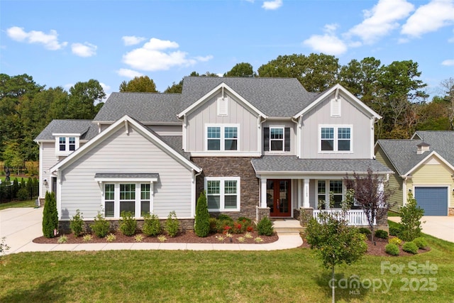 craftsman-style house with french doors, a porch, board and batten siding, stone siding, and driveway