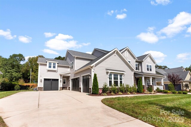 view of front facade with board and batten siding, concrete driveway, a front lawn, and a garage