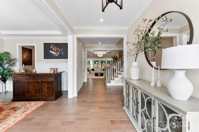 foyer featuring recessed lighting, a wainscoted wall, stairway, light wood finished floors, and crown molding