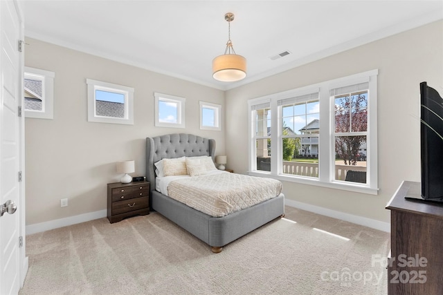 carpeted bedroom featuring ornamental molding, visible vents, and baseboards