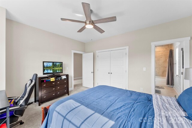 carpeted bedroom featuring ceiling fan, a closet, baseboards, and ensuite bathroom