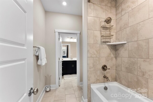 bathroom featuring tile patterned flooring, vanity, baseboards, and shower / bathing tub combination