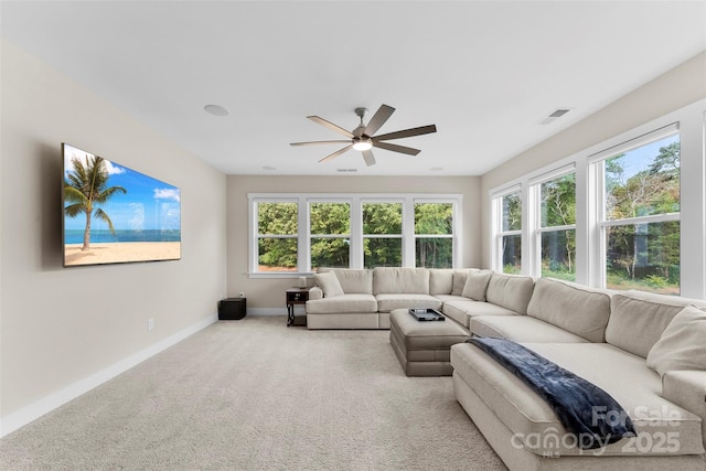 living room featuring carpet floors, visible vents, baseboards, and a ceiling fan