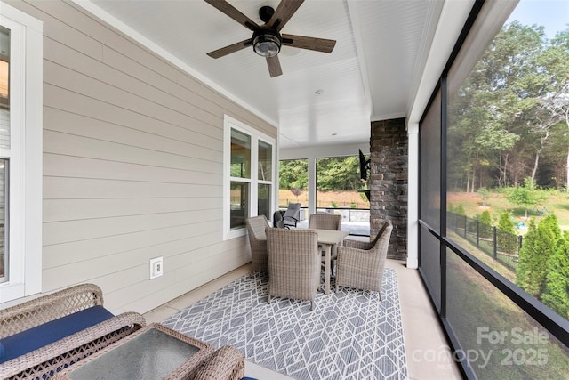 sunroom / solarium featuring a ceiling fan