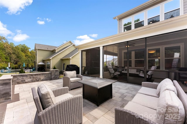 view of patio with a sunroom, an outdoor living space with a fire pit, fence, and grilling area