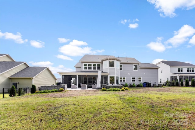 back of house with a sunroom, fence, a lawn, and a patio