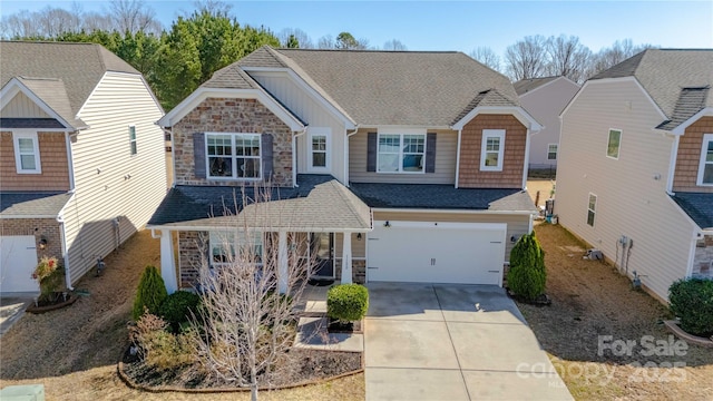 view of front of home featuring stone siding, driveway, an attached garage, and a shingled roof