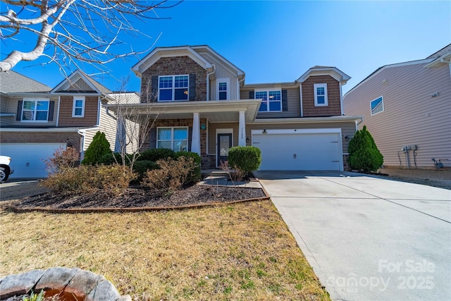 craftsman-style home with a front yard, covered porch, stone siding, and driveway