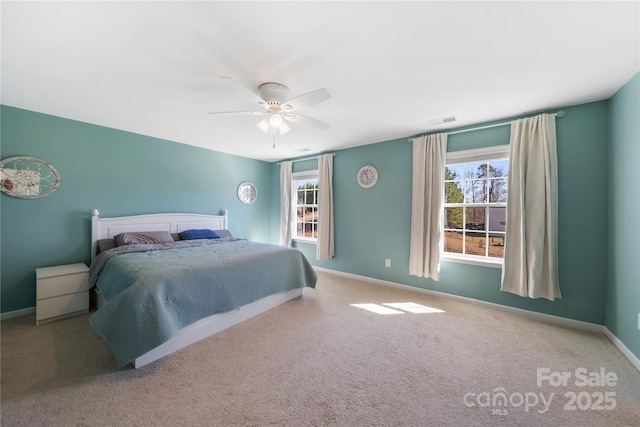 carpeted bedroom with visible vents, baseboards, and a ceiling fan