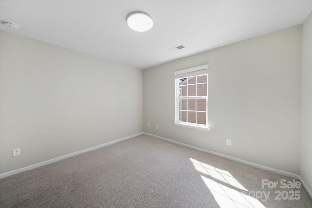 empty room with carpet, baseboards, and visible vents