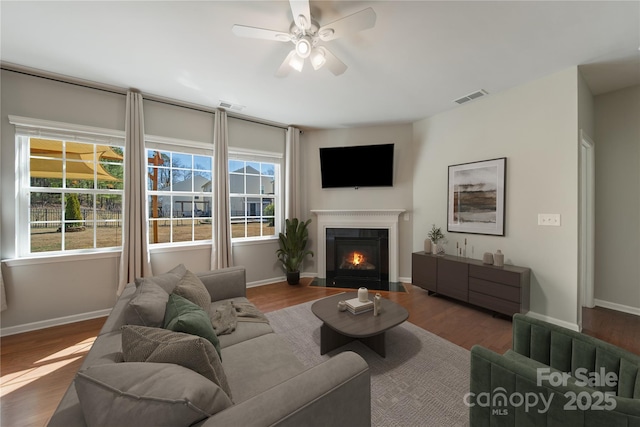 living room with wood finished floors, visible vents, and a wealth of natural light