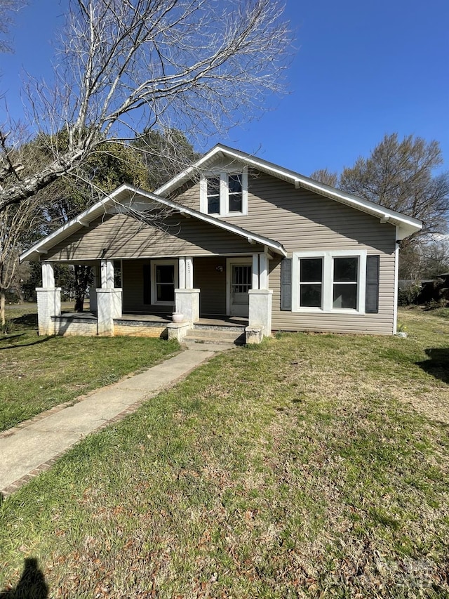 bungalow-style house with covered porch and a front lawn