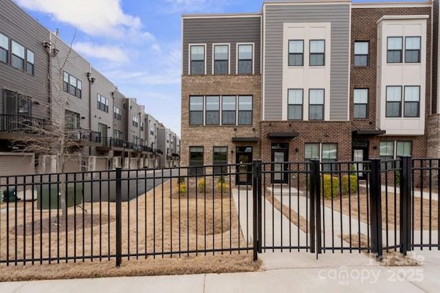 view of property featuring fence and brick siding