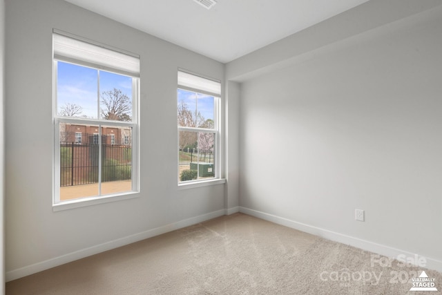 spare room featuring carpet flooring and baseboards