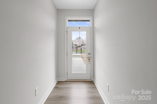 doorway featuring wood finished floors and baseboards