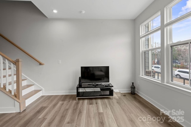 living area with light wood finished floors, stairway, recessed lighting, and baseboards