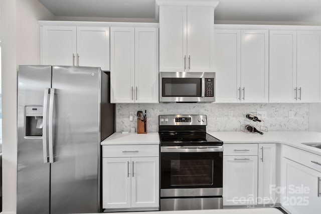 kitchen with light countertops, appliances with stainless steel finishes, backsplash, and white cabinets