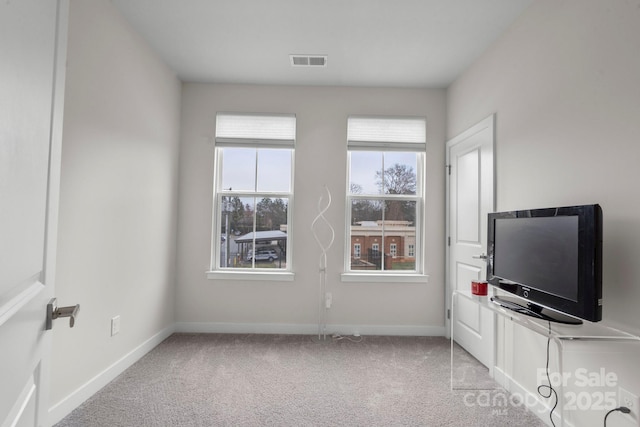 interior space with light carpet, baseboards, and visible vents