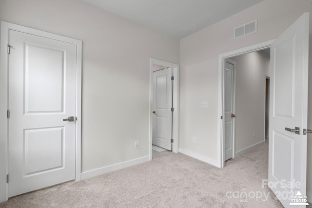 unfurnished bedroom with light carpet, baseboards, and visible vents