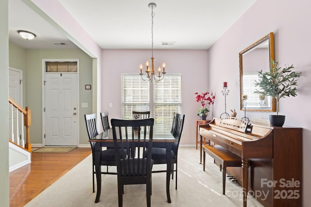 dining space featuring stairway, visible vents, baseboards, and an inviting chandelier