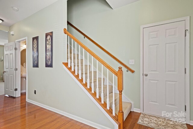 stairway with baseboards and wood finished floors