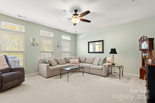 living room with carpet flooring, visible vents, baseboards, and a ceiling fan