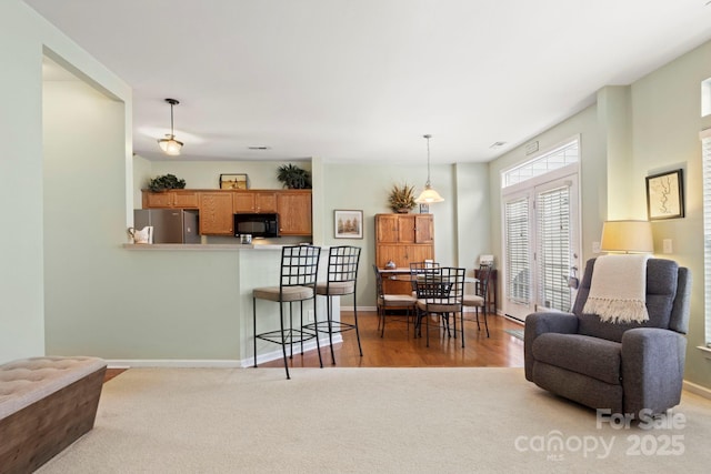 living room with baseboards and light carpet