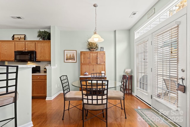 dining room with visible vents, baseboards, and light wood-style floors