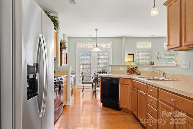 kitchen featuring electric range oven, a sink, light countertops, stainless steel refrigerator with ice dispenser, and dishwasher