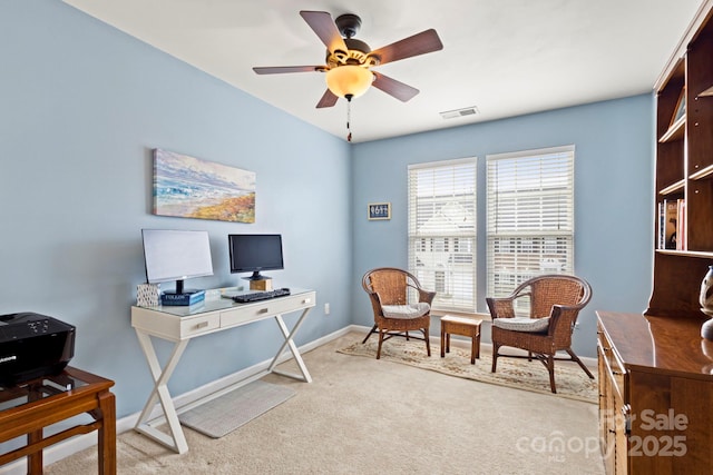 office area featuring carpet flooring, visible vents, baseboards, and a ceiling fan