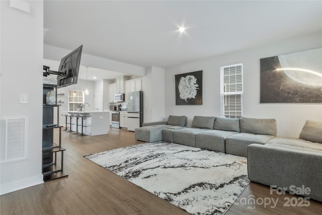 living room with visible vents and wood finished floors