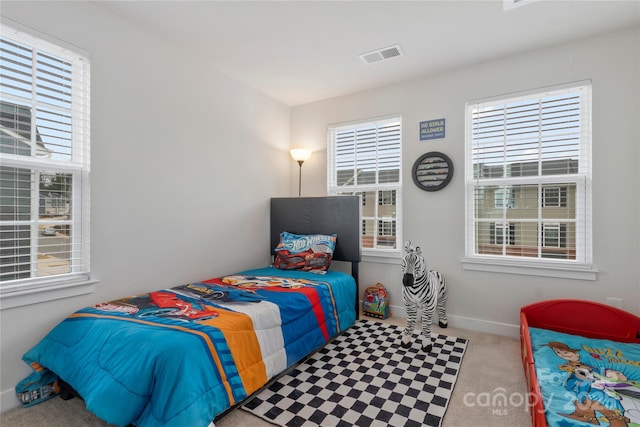 bedroom featuring visible vents, baseboards, and carpet