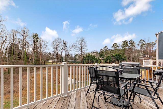 deck with grilling area and outdoor dining area