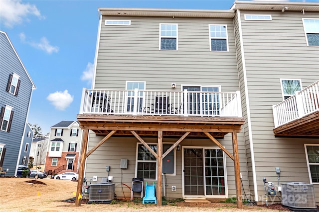 rear view of house with central air condition unit and a deck