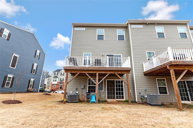 rear view of house with central AC unit and a wooden deck