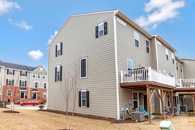 back of property featuring central AC unit and a deck