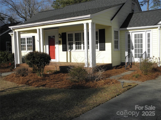 bungalow-style home with entry steps, covered porch, and roof with shingles