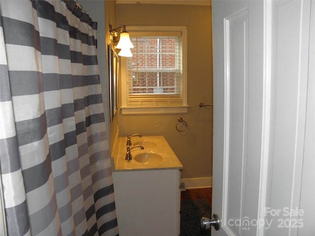 full bath featuring a shower with shower curtain, vanity, and baseboards