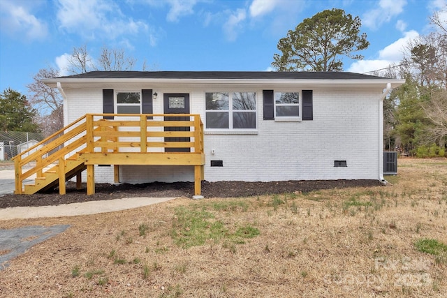 view of front of house with crawl space, a wooden deck, cooling unit, and brick siding